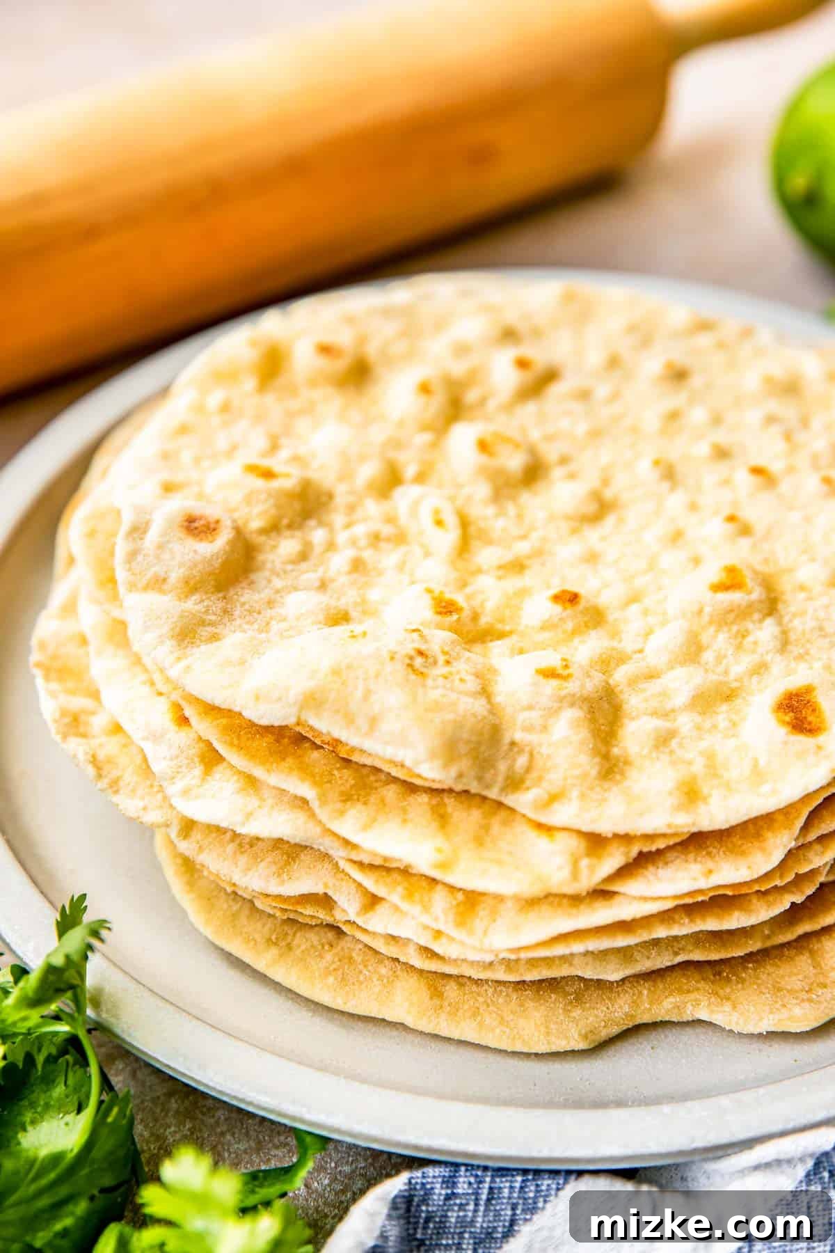 Craft Your Own Perfect Flour Tortillas 2 A beautiful stack of warm, homemade flour tortillas resting on a plate, ready to be served and enjoyed.