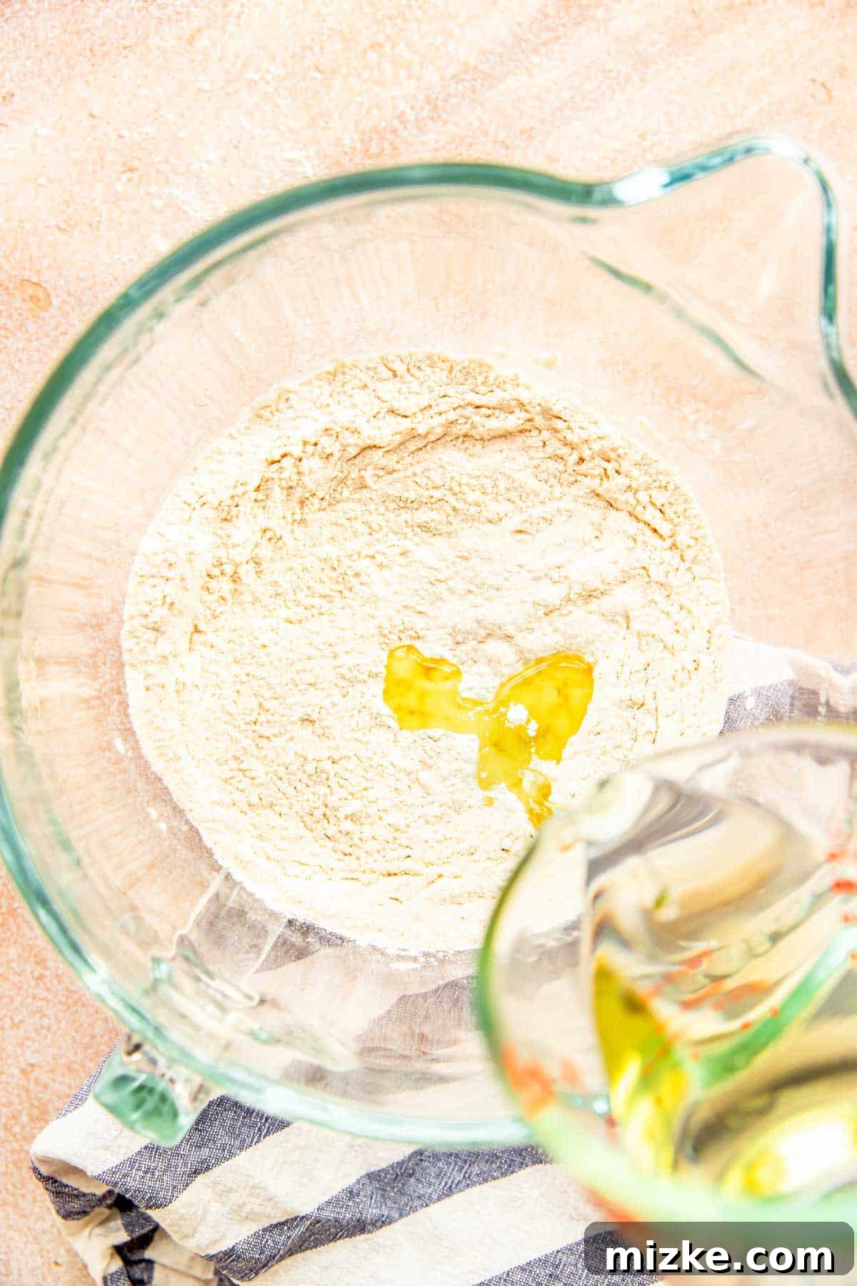 Craft Your Own Perfect Flour Tortillas 3 Dry ingredients (flour, salt, baking powder) in a glass stand mixer bowl, with vegetable oil being poured in.