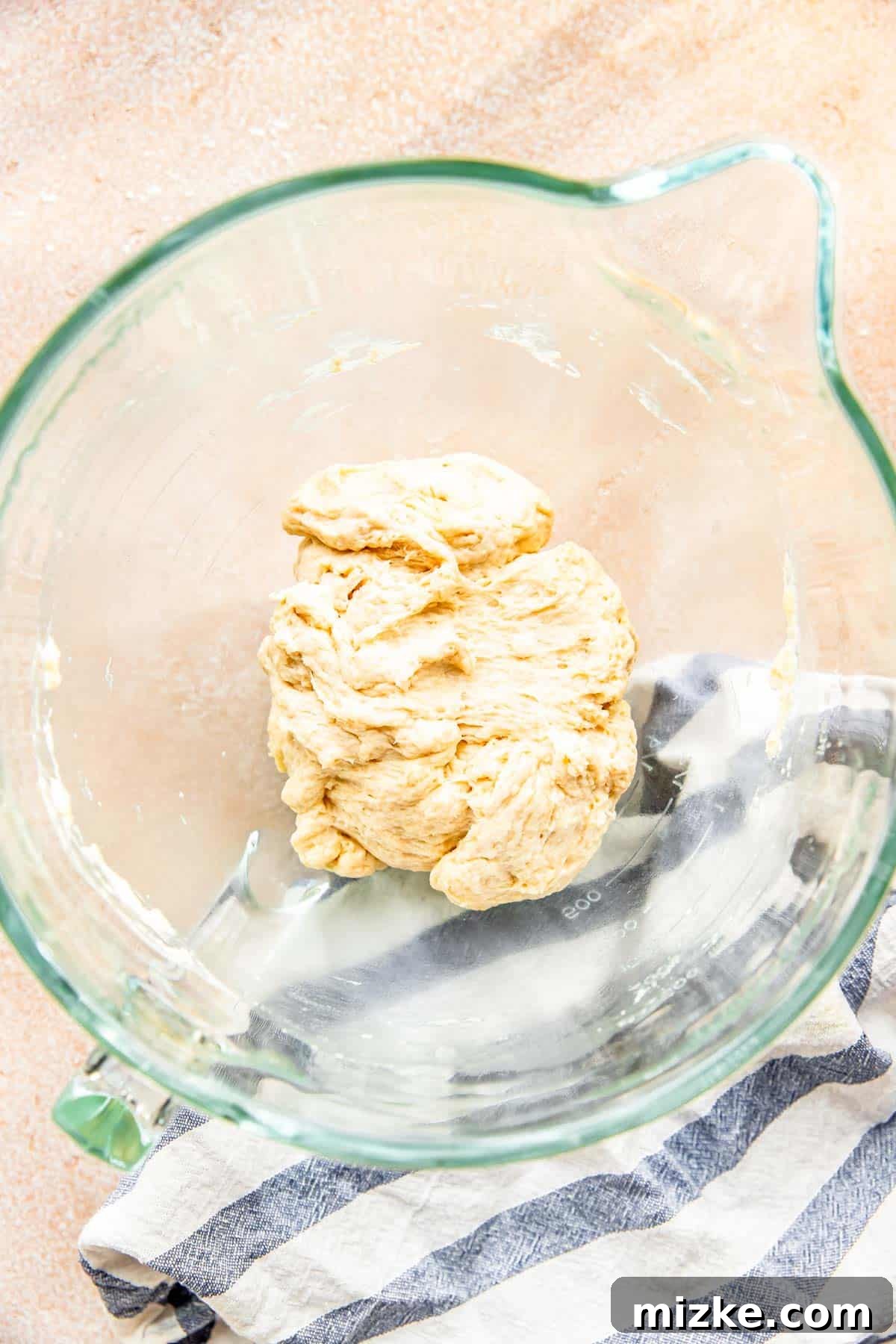 Craft Your Own Perfect Flour Tortillas 4 A perfectly smooth and elastic ball of flour tortilla dough resting in a clear glass stand mixer bowl.