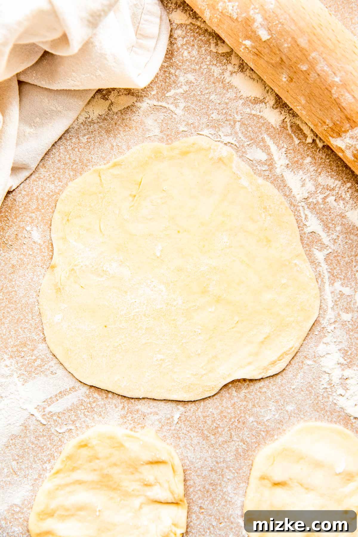 Craft Your Own Perfect Flour Tortillas 6 A rolling pin rolling out a dough ball into a perfectly thin, 6-inch diameter circle on a lightly floured countertop.