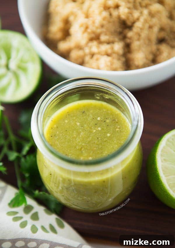 Fresh homemade salsa verde in a glass jar, accompanied by bright green limes and a bowl of fluffy quinoa, ready to be served.