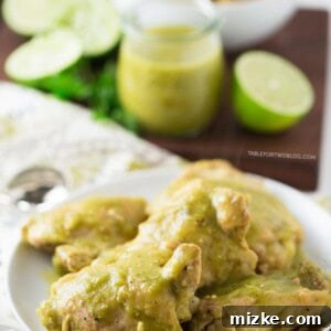 Slow cooker salsa verde chicken on a plate next to salsa verde, limes, and a bowl of quinoa.