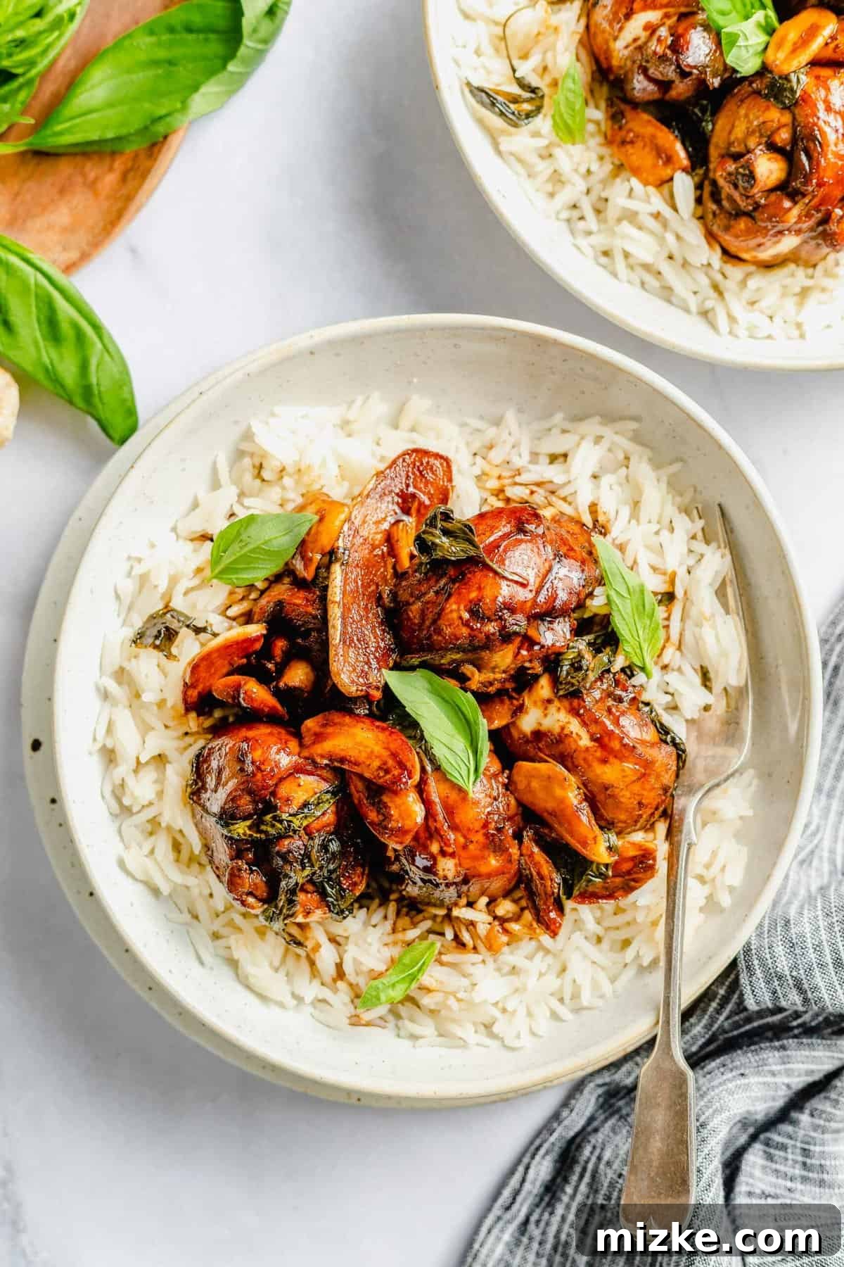 This authentic Taiwanese recipe for three cup chicken (三杯雞) is easy enough to make at home, so you won't have to get it from a restaurant! Overhead view of three cup chicken in bowl with rice.