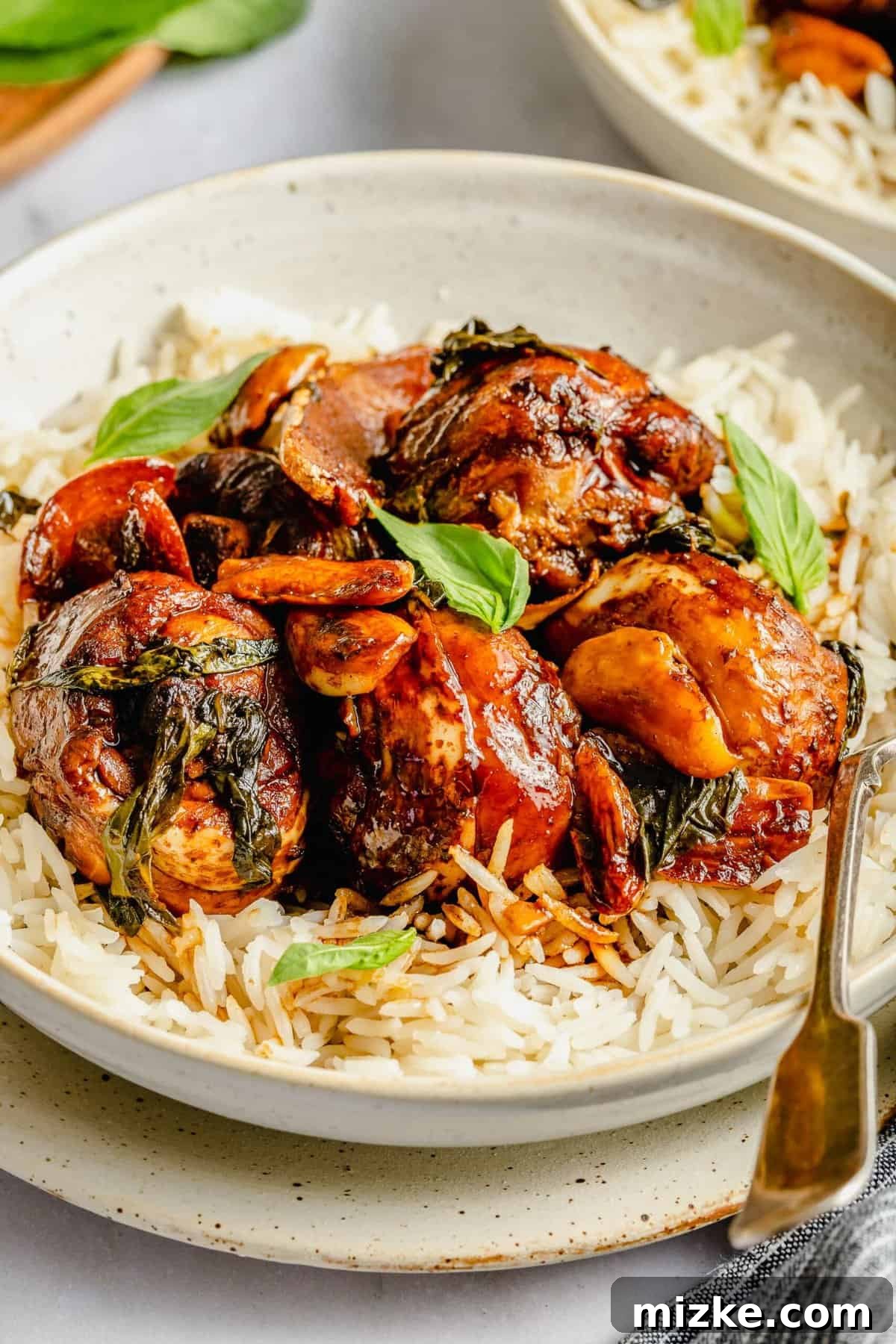 This authentic Taiwanese recipe for three cup chicken (三杯雞) is easy enough to make at home, so you won't have to get it from a restaurant! Bowl of rice topped with three cup chicken.