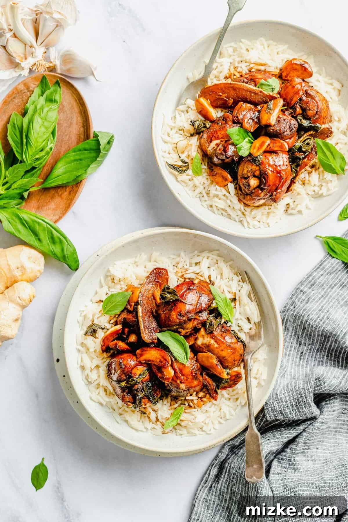 This authentic Taiwanese recipe for three cup chicken (三杯雞) is easy enough to make at home, so you won't have to get it from a restaurant! Overhead view of two bowls of three cup chicken and rice.