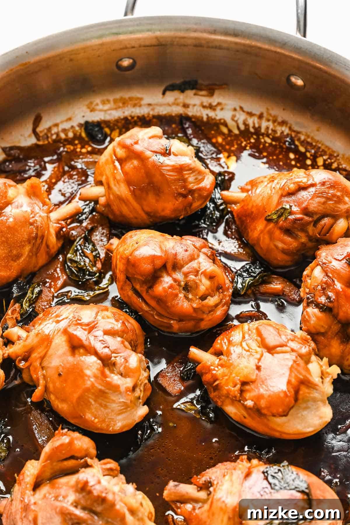 This authentic Taiwanese recipe for three cup chicken (三杯雞) is easy enough to make at home, so you won't have to get it from a restaurant! Close up view of three cup chicken in a skillet.