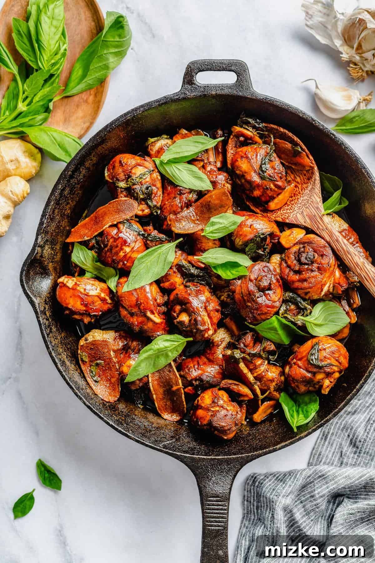 This authentic Taiwanese recipe for three cup chicken (三杯雞) is easy enough to make at home, so you won't have to get it from a restaurant! Three cup chicken in cast iron skillet with basil leaves.