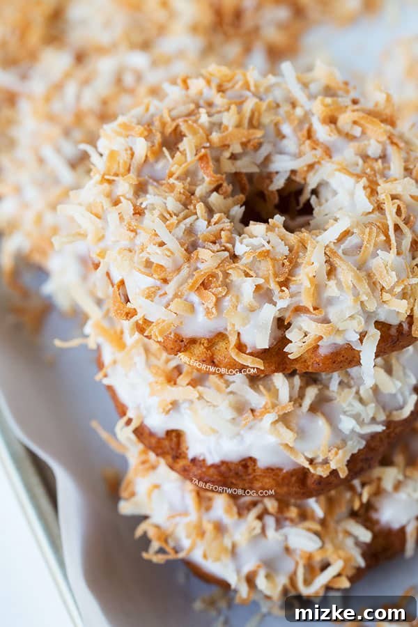Stack of Triple Coconut Donuts on a cooling rack, perfectly glazed