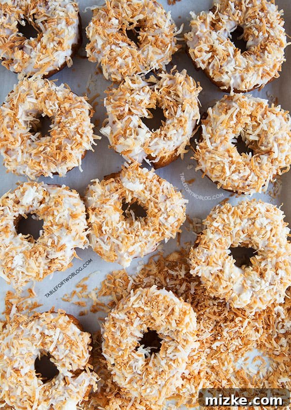 Basket of finished Triple Coconut Donuts, perfectly glazed and topped with toasted coconut