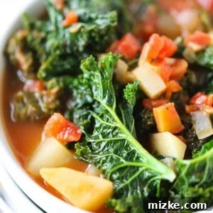 A steaming bowl of Tomato, Kale, and Potato Soup, ready to be enjoyed.