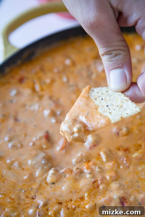 Serve this easy Chorizo Pimento Cheese Dip at your next Super Bowl party for guaranteed rave reviews! An overhead shot of Chorizo Pimento Cheese Dip served with a variety of colorful tortilla chips.