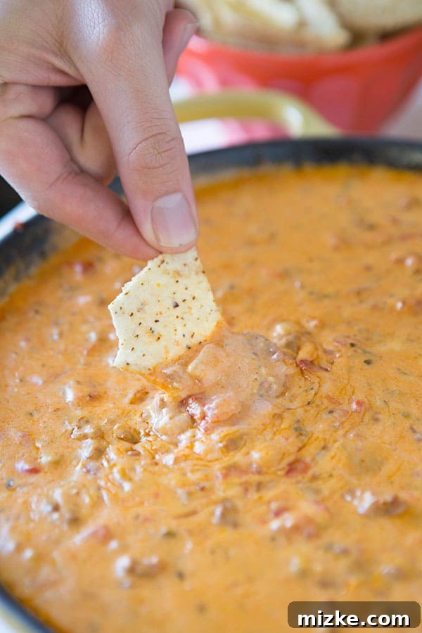 The perfect warm dip for any gathering: Chorizo Pimento Cheese Dip from tablefortwoblog.com A side view of the delicious Chorizo Pimento Cheese Dip in a skillet, showcasing its rich texture and melted cheese.
