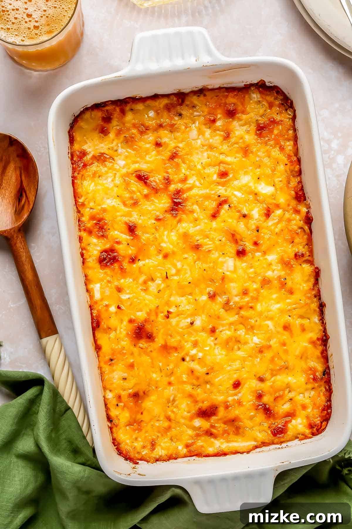 Irresistible Cheesy Hashbrown Bake 2 Golden brown cheesy hashbrown casserole baked to perfection, straight out of the oven, with bubbly cheese on top.