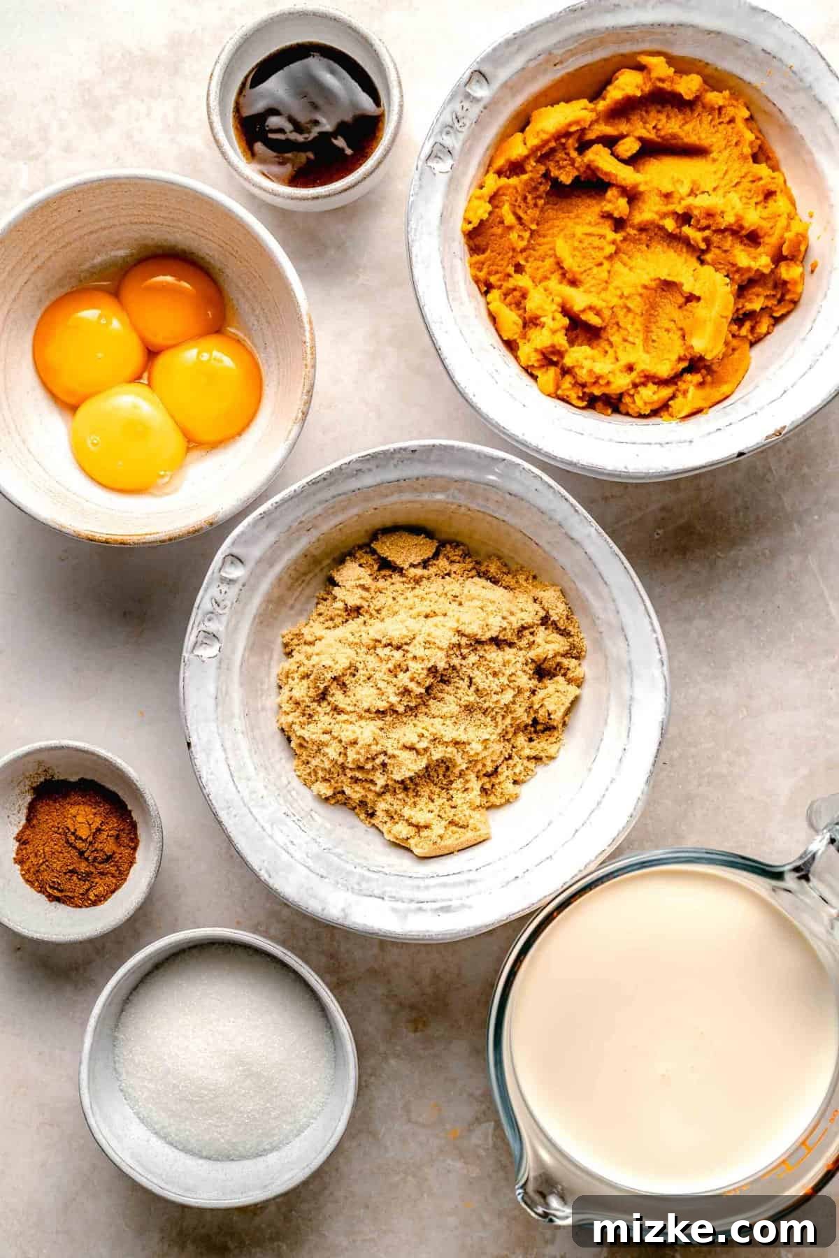 Creamy, restaurant-quality pumpkin creme brulee is infused with just the right amount of pumpkin & has the perfect caramelized sugar topping. Individual ingredients for pumpkin creme brulee laid out: heavy cream, vanilla bean paste, egg yolks, brown sugar, pumpkin puree, pumpkin pie spice, and granulated sugar.