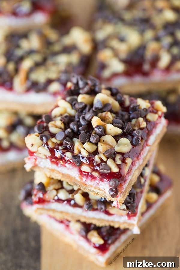 An overhead shot of a single Raspberry Coconut Bar, highlighting the texture of the coconut flakes and the rich color of the raspberry preserves.