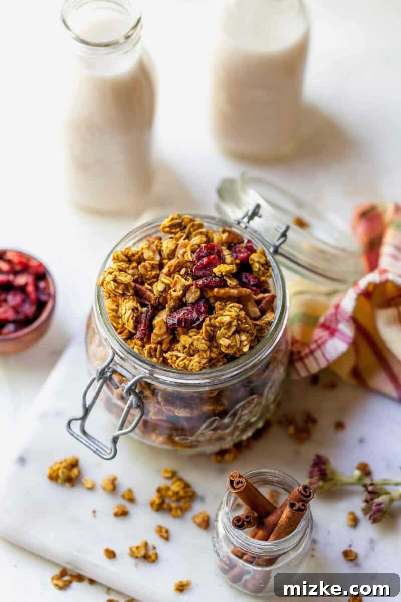 Spiced Pumpkin Cranberry Crunch 3 Close-up of baked Pumpkin Cranberry Granola cooling on a tray, showcasing its crunchy texture and vibrant ingredients.