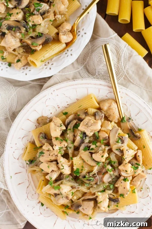 Creamy Marsala Chicken Rigatoni with Mushrooms 3 A vibrant, overhead shot of a large serving bowl filled with chicken rigatoni and mushroom marsala, showcasing the ample chicken pieces, sliced mushrooms, and creamy sauce.