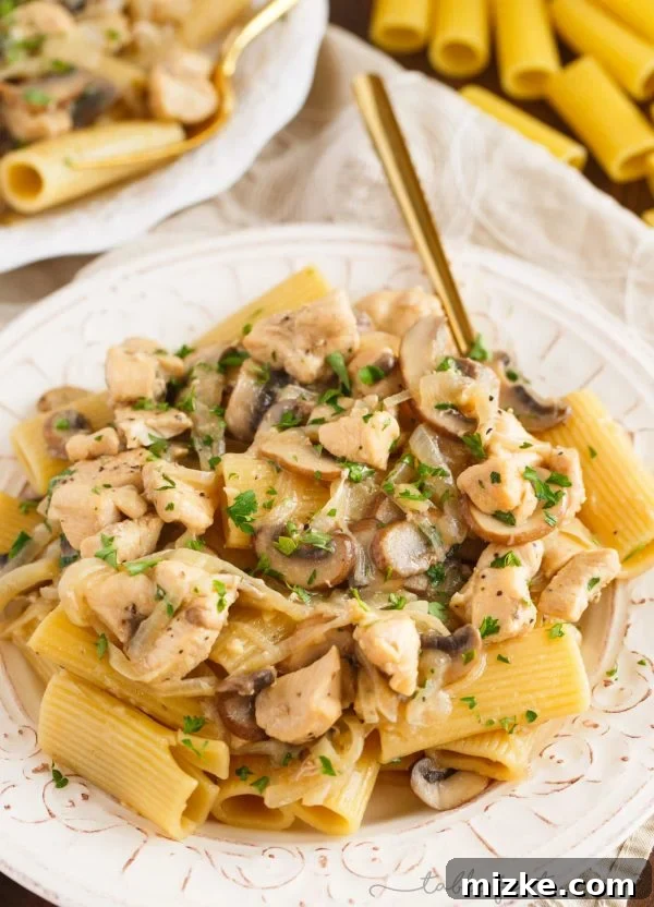 Creamy Marsala Chicken Rigatoni with Mushrooms 4 A close-up of a serving of chicken rigatoni and mushroom marsala, showing the texture of the pasta and sauce, with visible pieces of chicken and mushrooms.