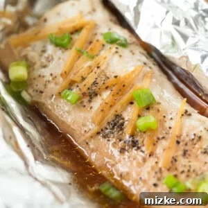 Cooked Ginger Soy Sesame Fish in a Pouch served with rice and broccoli.