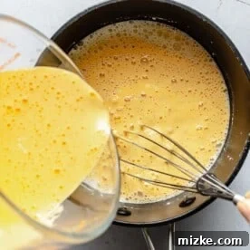 Whisking tempered egg yolks into custard for ice cream.