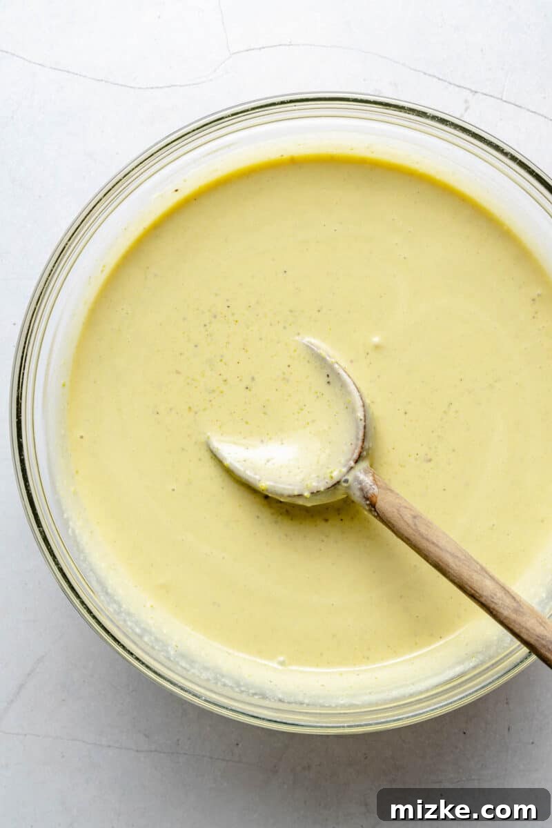 Velvet Pistachio Dream 6 Pistachio ice cream base in a bowl with a wooden spoon, ready for chilling.