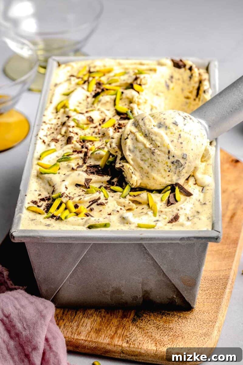 Velvet Pistachio Dream 8 Scooping pistachio ice cream out of a loaf pan, showing its creamy texture.