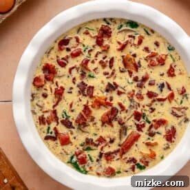 bacon pieces sprinkled on top of egg mixture in a baking dish