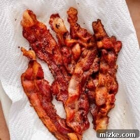 6 slices of crispy bacon on a paper towel lined plate