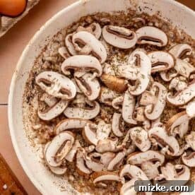 sliced mushrooms and thyme added to the shallots in the skillet with bacon grease