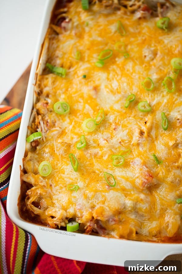Sky High Chicken Enchiladas 4 Overhead view of a baking dish filled with stacked chicken enchiladas, fresh from the oven