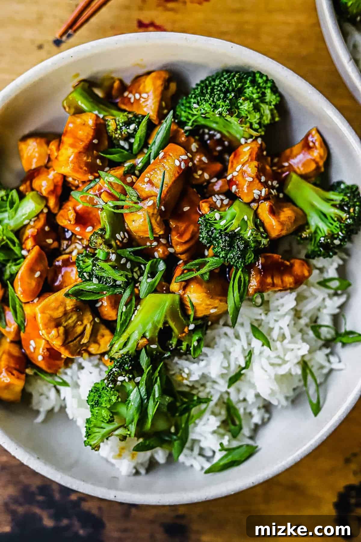 This 20-minute teriyaki chicken and broccoli recipe is made with juicy chicken and tender broccoli. It's healthy and better than takeout! overhead shot showing the teriyaki chicken and broccoli with rice sprinkled with green onions and sesame seeds