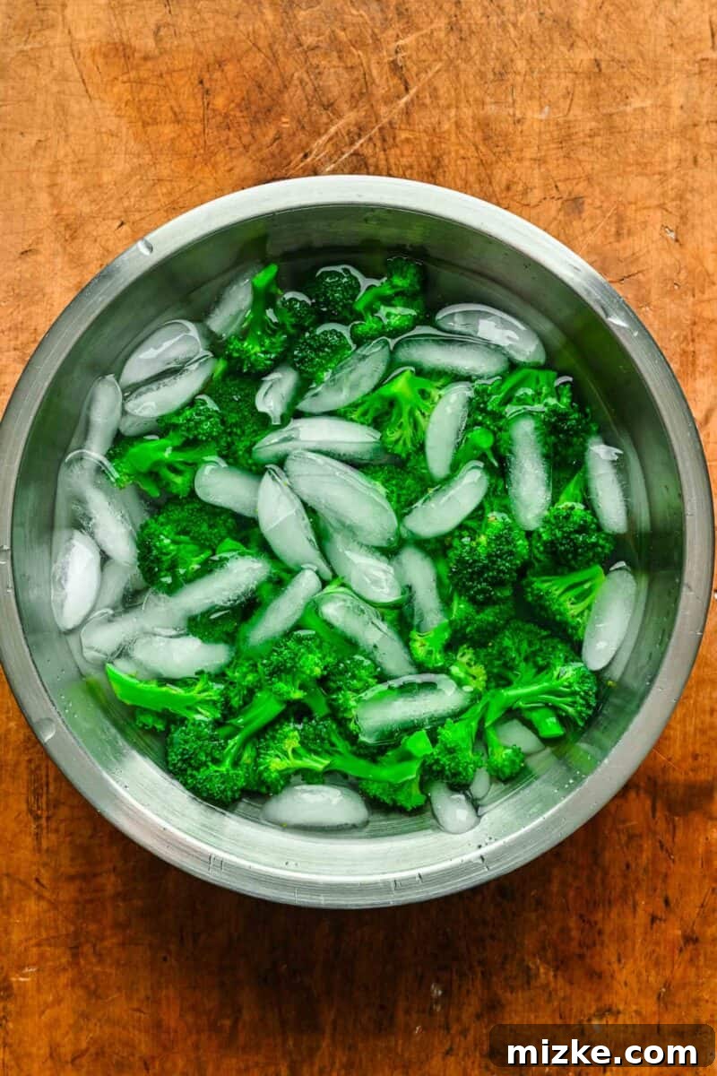 This 20-minute teriyaki chicken and broccoli recipe is made with juicy chicken and tender broccoli. It's healthy and better than takeout! Blanched broccoli florets in a bowl of ice water.