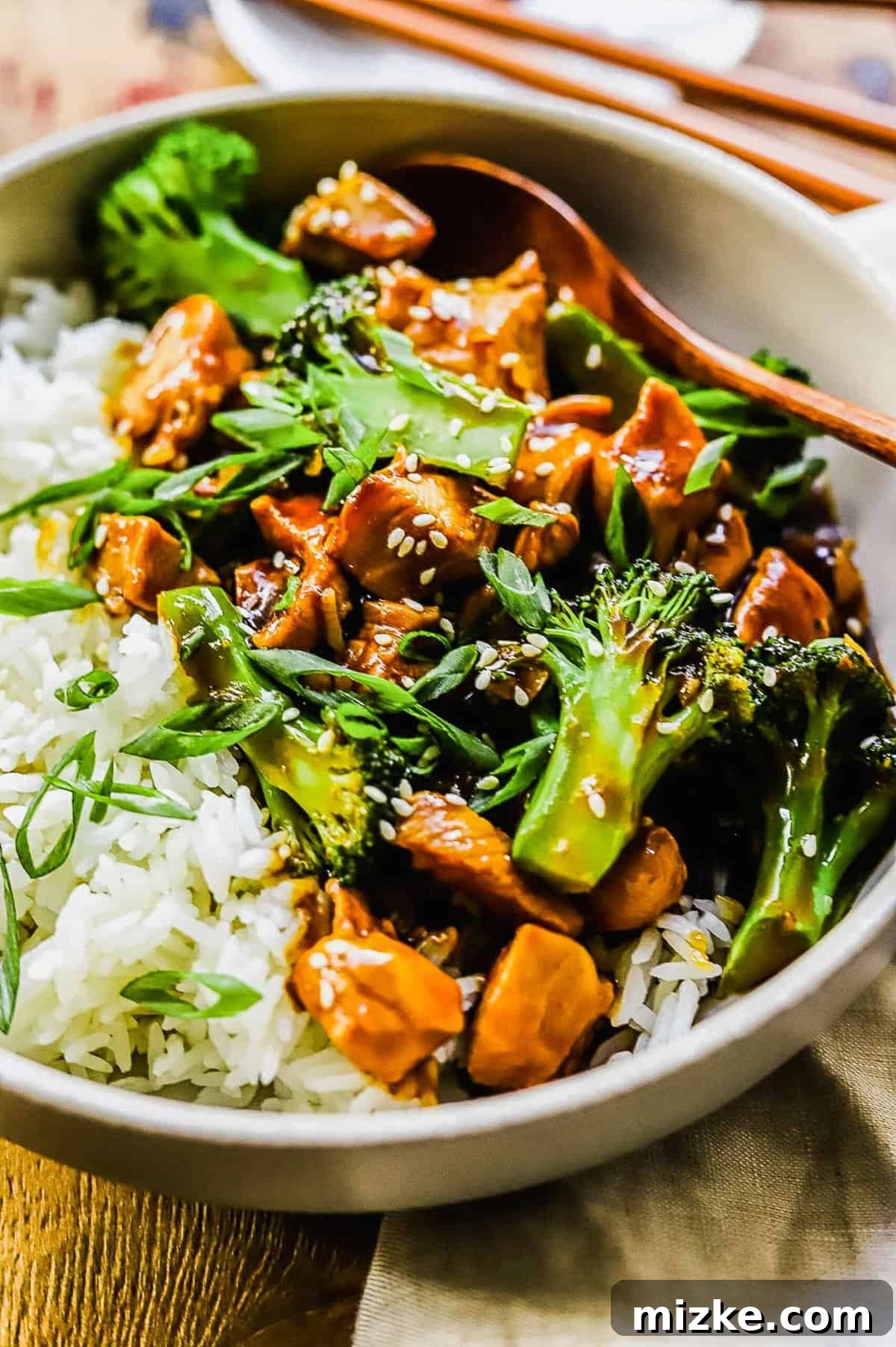 This 20-minute teriyaki chicken and broccoli recipe is made with juicy chicken and tender broccoli. It's healthy and better than takeout! close up of teriyaki chicken and broccoli in a white bowl
