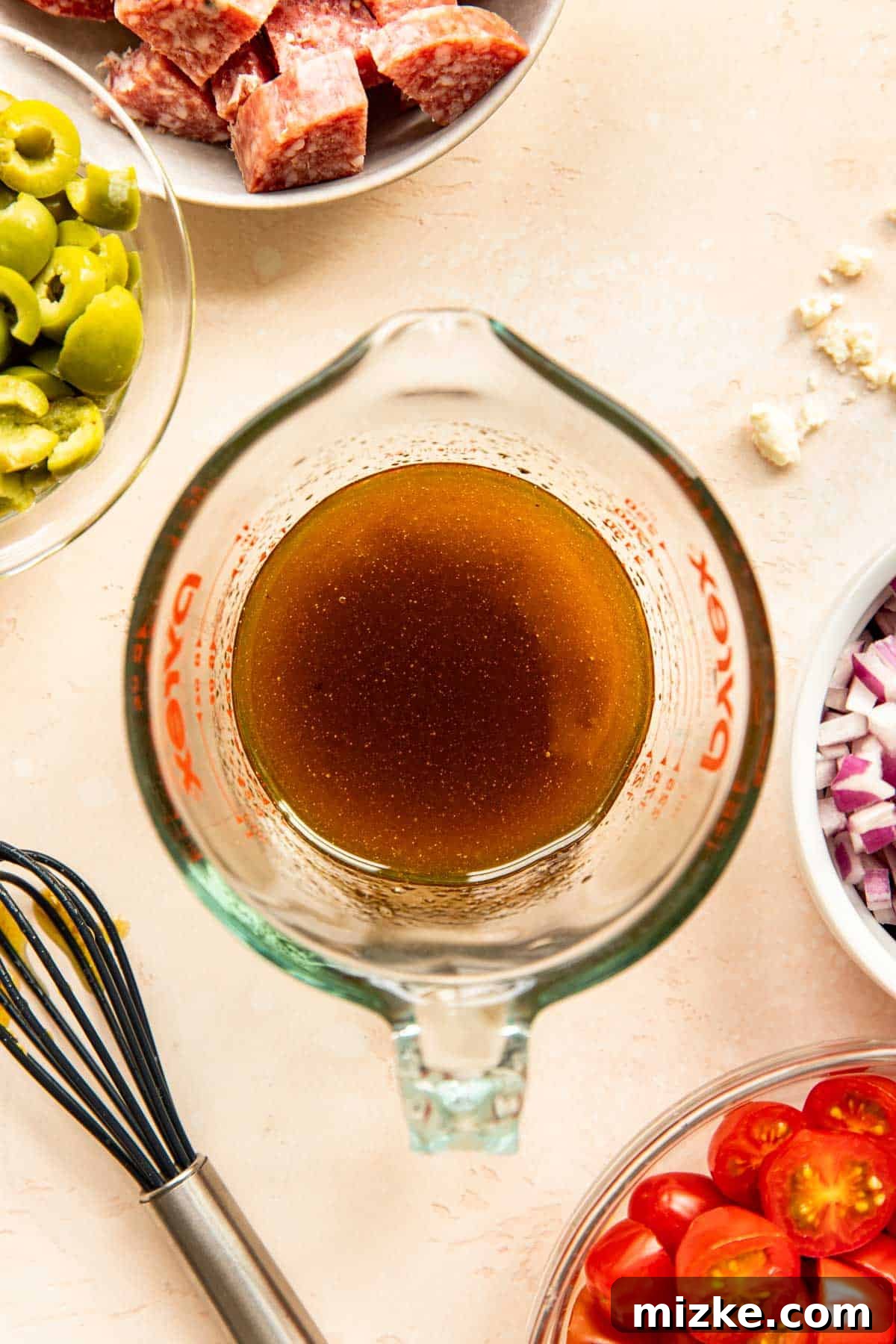 Whisking the Dressing The dressing ingredients—olive oil, balsamic vinegar, garlic, and seasonings—are vigorously whisked together in a glass measuring cup, creating a homogenous and zesty mixture.