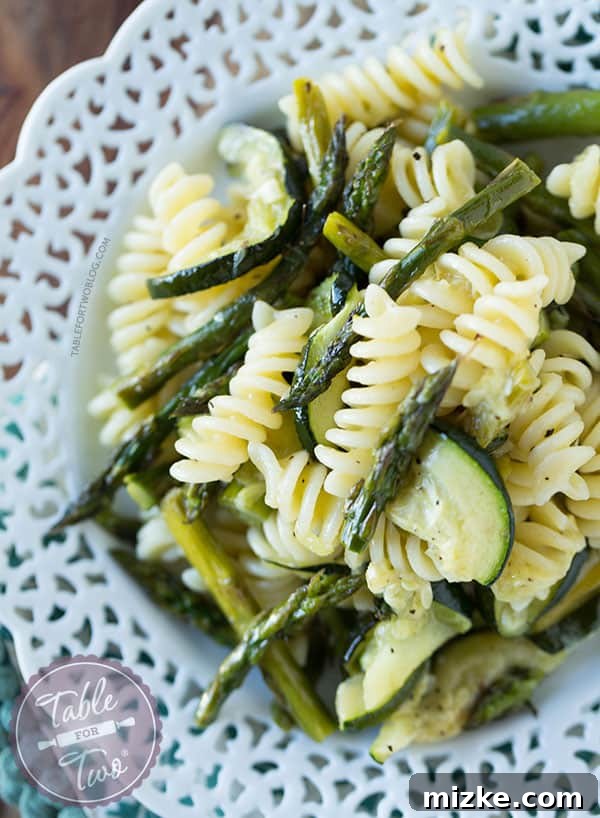 Smoky Grilled Asparagus and Zucchini Pasta 3 Two elegant, oversized wine glasses, similar to those seen on the show Scandal, standing on a polished surface.