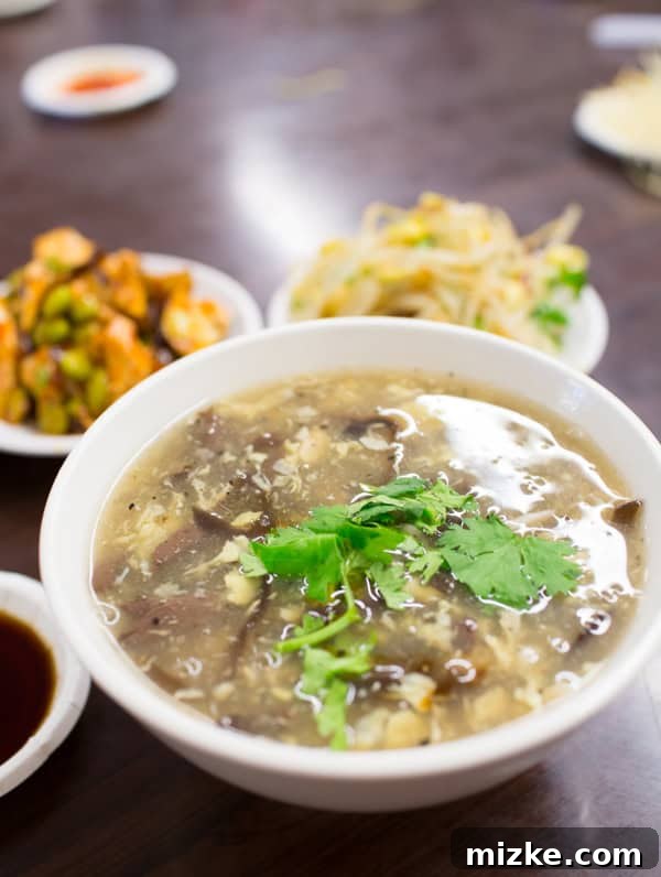 A steaming bowl of sweet and sour soup with vegetables