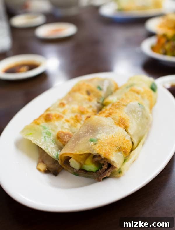Savory beef roll-up in a scallion pancake with a rich sauce