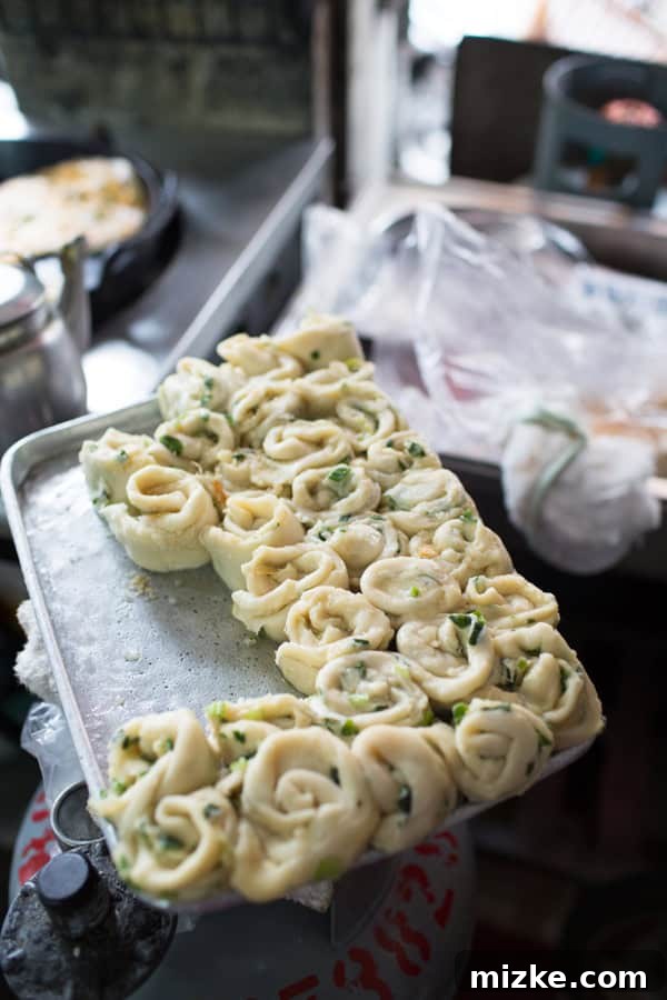 Raw scallion pancakes prepared for cooking on a griddle