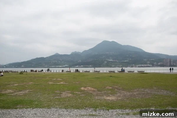 Scenic view of Danshui coastline with boats and mountains in the distance