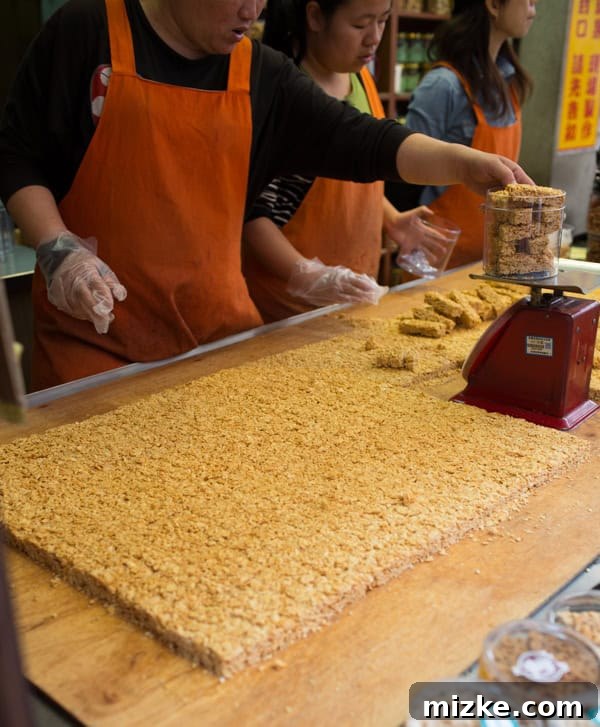 Vendor making fresh almond granola bars on Danshui Old Street