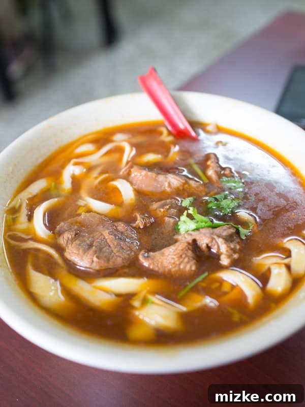 Kaohsiung: Taiwan's Vibrant Southern Hub 15 A steaming bowl of traditional Taiwanese beef noodle soup with rich broth, tender beef, and fresh herbs