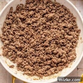 Savory Beef Enchiladas 12 browned ground beef in a white nonstick skillet