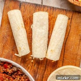 Savory Beef Enchiladas 15 corn tortillas rolled with seam side down on a cutting board