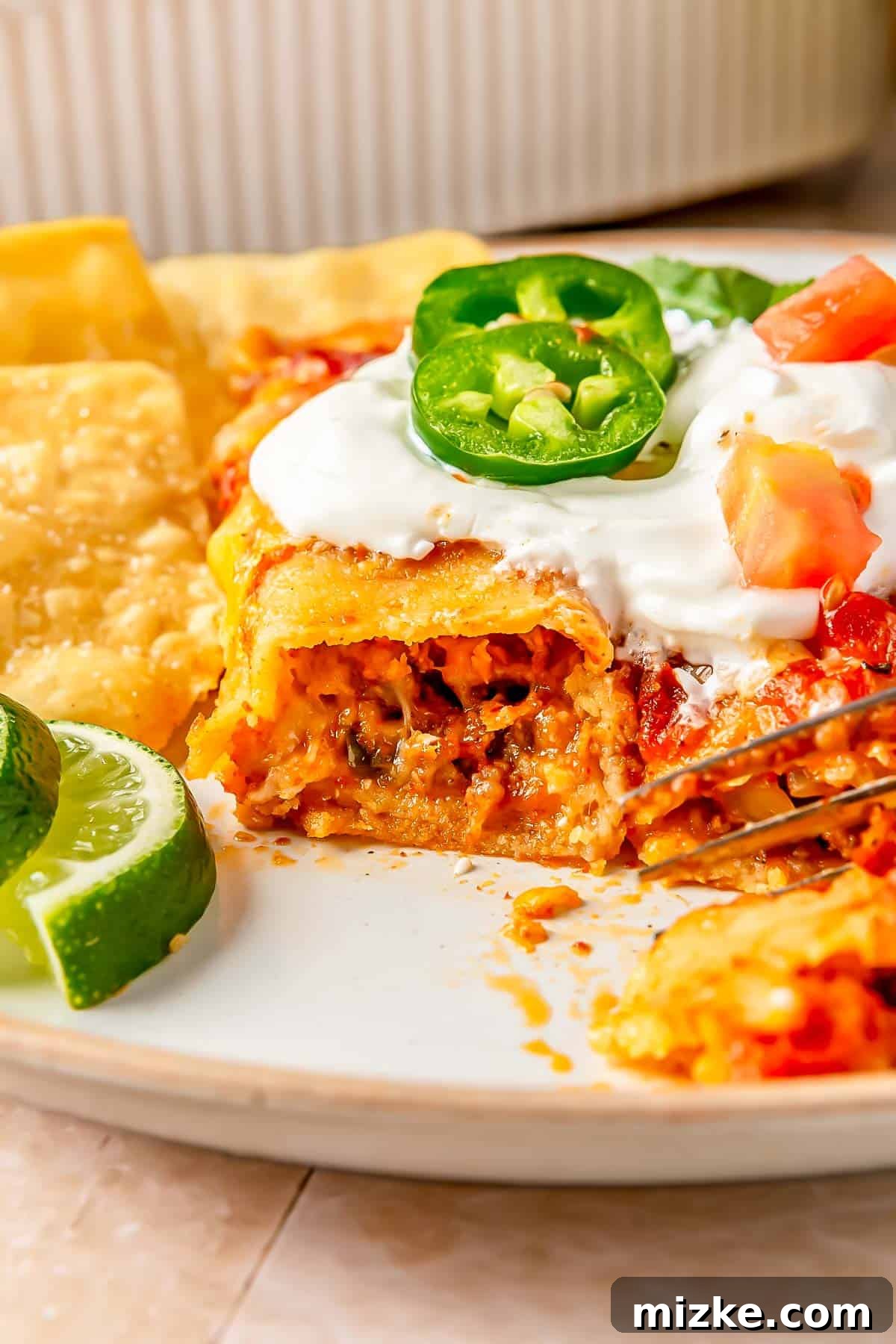 Savory Beef Enchiladas 17 A close-up view of a beef enchilada cut open, revealing the layers of seasoned ground beef, melted cheese, and corn tortilla, with the rich red sauce.