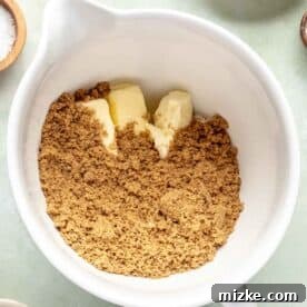 Softened butter, dark brown sugar, and granulated sugar creaming together in a stand mixer bowl, turning light and fluffy.