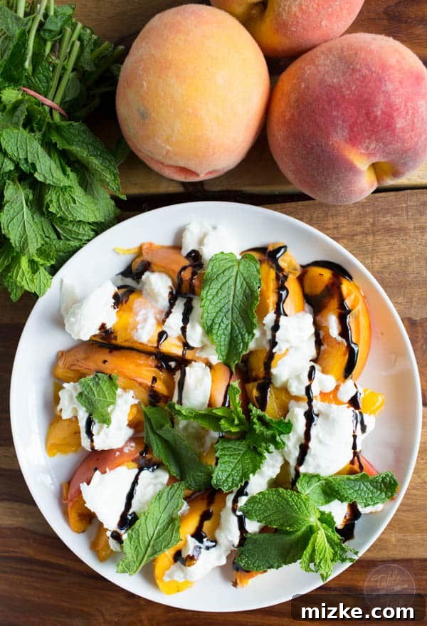 Caramelized Peach Burrata Bliss 3 Close-up of grilled peaches with burrata, mint, and balsamic drizzle on a plate, highlighting the textures and vibrant colors.