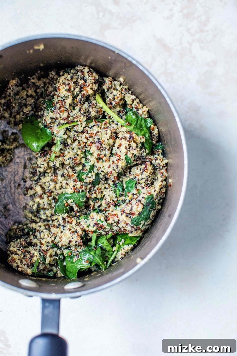 Close-up view of the spinach pesto quinoa bowl, highlighting the texture of quinoa and fresh spinach.