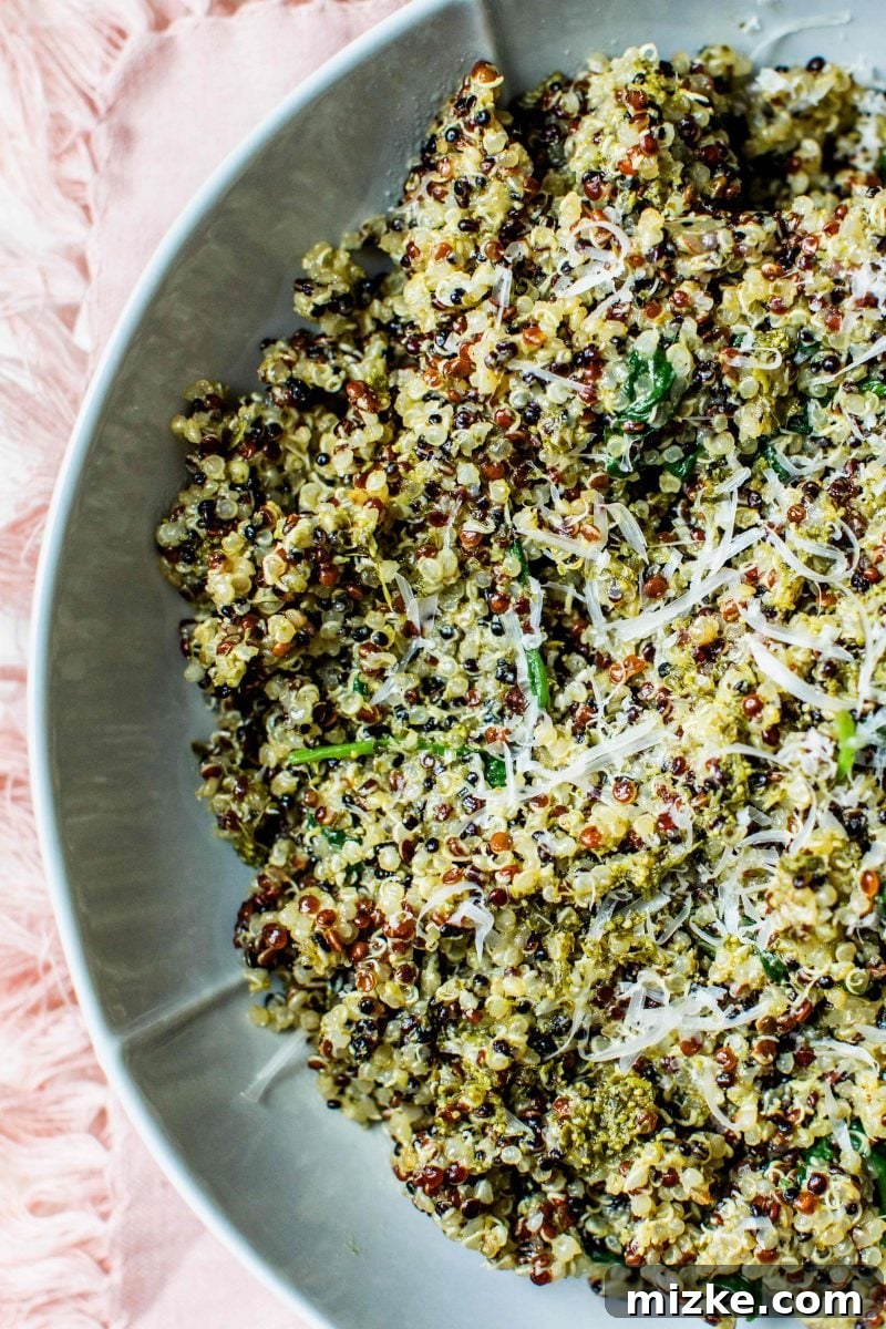 A serving of the 15-minute spinach pesto quinoa bowl topped with additional ingredients.
