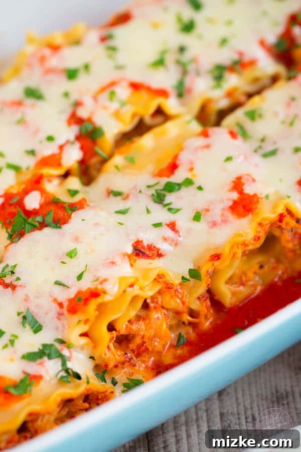 Gourmet Chicken and Roasted Red Pepper Lasagna Pinwheels 3 Close-up of golden brown Roasted Red Pepper Chicken Lasagna Rolls, topped with melted mozzarella.