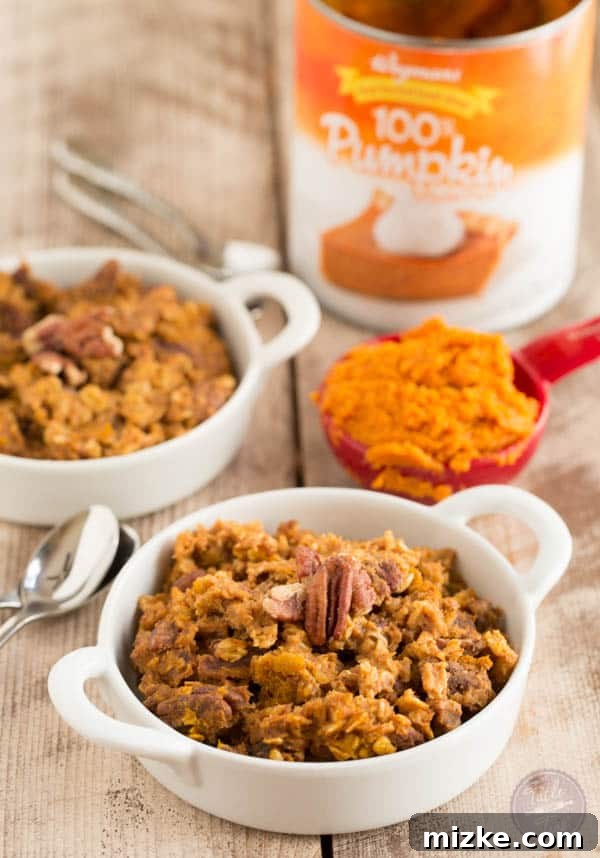 Cozy Pumpkin Spice Baked Oatmeal 3 Delicious baked oatmeal, garnished with fresh berries and a light drizzle, served in individual bowls.